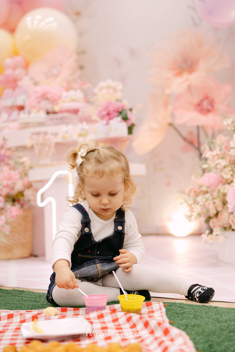 Aniversário de 1 ano da Luiza realizado no Buffet Santa Arruaça em Mogi das Cruzes, com decoração Jardim da Luiza assinada pela Doce de Laço e registrado por Dani Umezaki