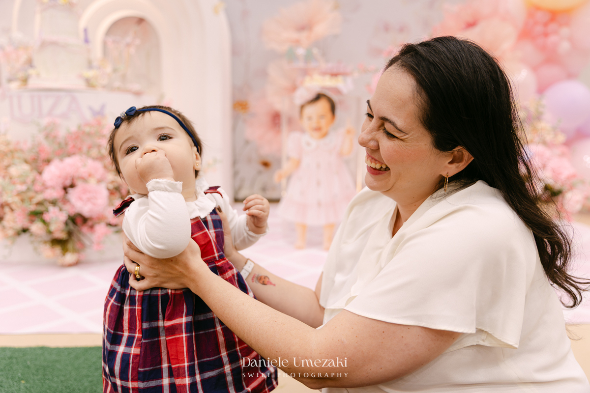 Aniversário de 1 ano da Luiza realizado no Buffet Santa Arruaça em Mogi das Cruzes, com decoração Jardim da Luiza assinada pela Doce de Laço e registrado por Dani Umezaki