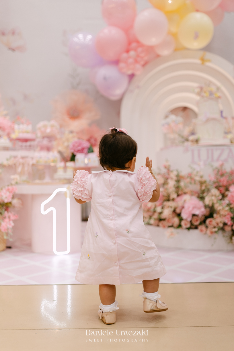 Aniversário de 1 ano da Luiza realizado no Buffet Santa Arruaça em Mogi das Cruzes, com decoração Jardim da Luiza assinada pela Doce de Laço e registrado por Dani Umezaki