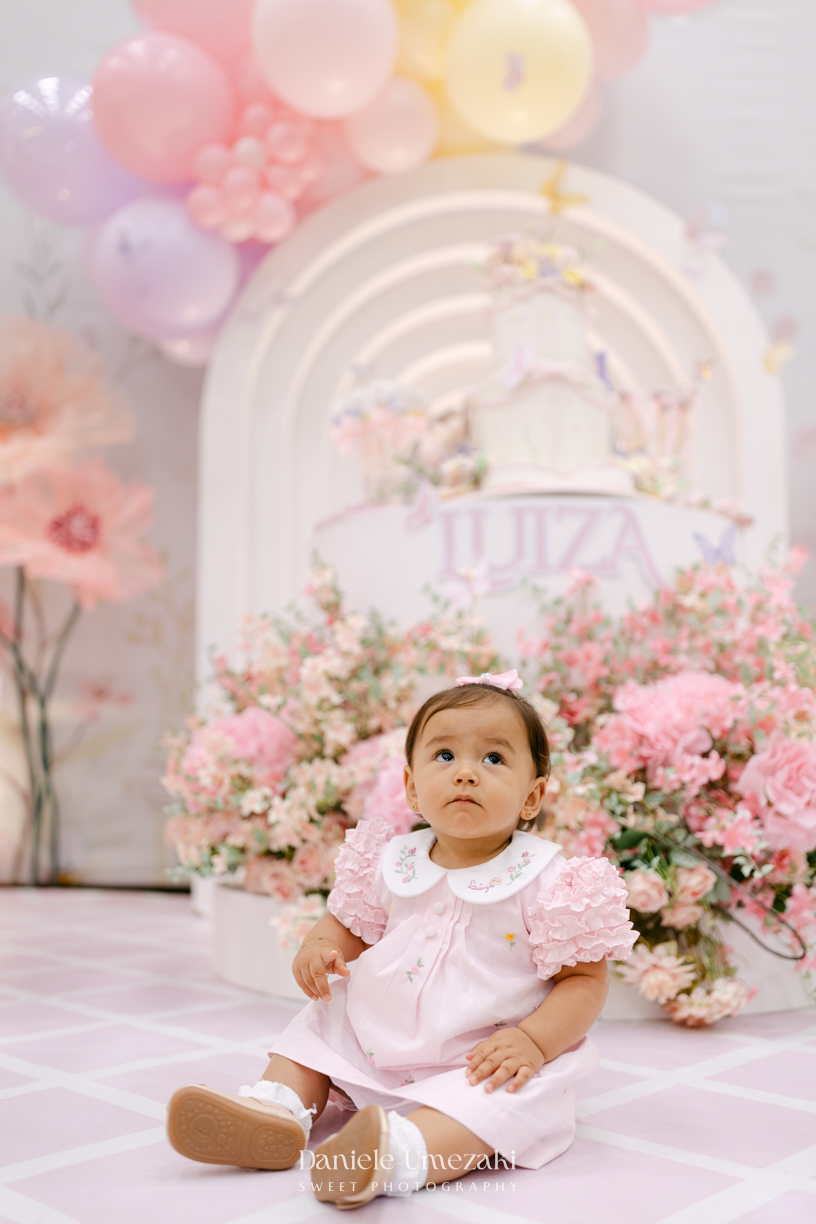 Aniversário de 1 ano da Luiza realizado no Buffet Santa Arruaça em Mogi das Cruzes, com decoração Jardim da Luiza assinada pela Doce de Laço e registrado por Dani Umezaki