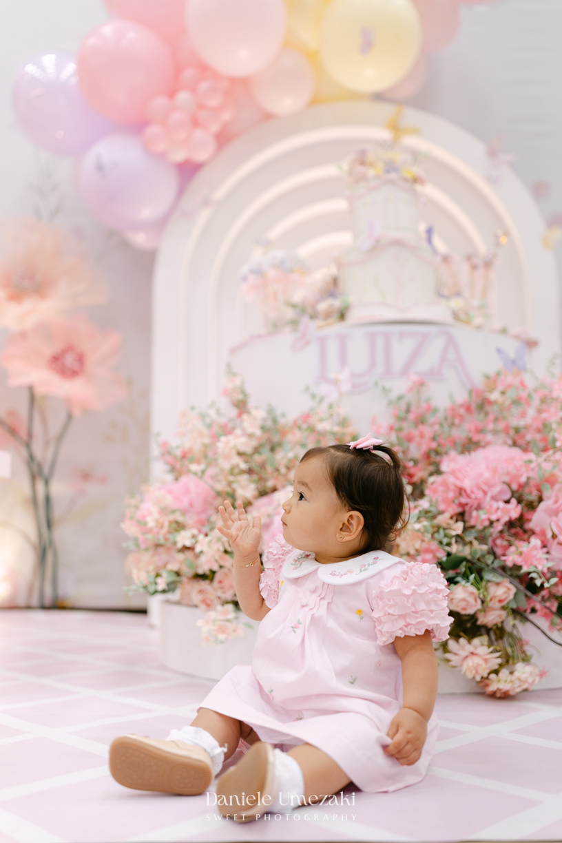 Aniversário de 1 ano da Luiza realizado no Buffet Santa Arruaça em Mogi das Cruzes, com decoração Jardim da Luiza assinada pela Doce de Laço e registrado por Dani Umezaki