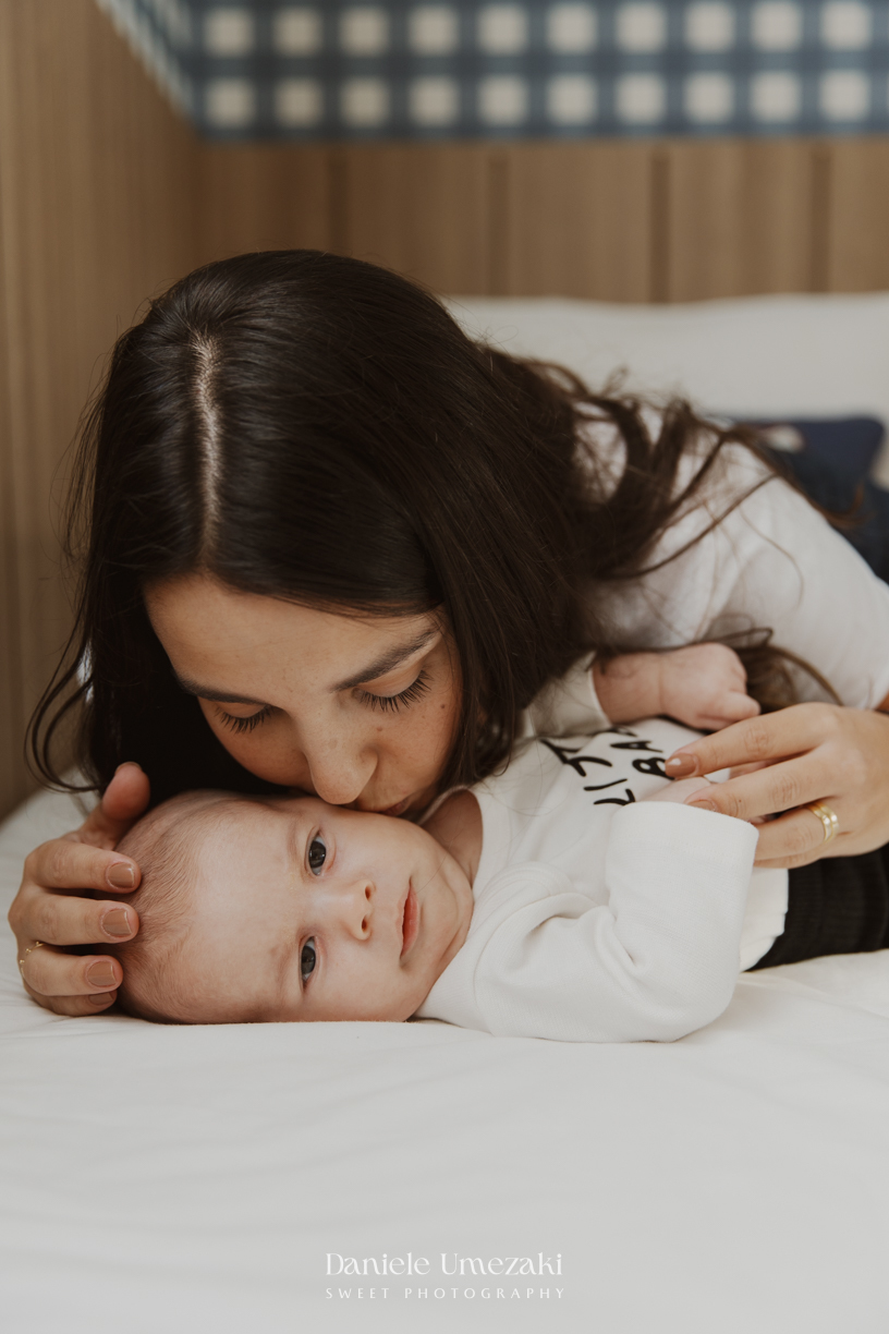 Família reunida durante ensaio lifestyle em casa em Arujá com o bebê Enrico de 2 meses, registrado por Dani Umezaki com fotografia leve, natural e atemporal