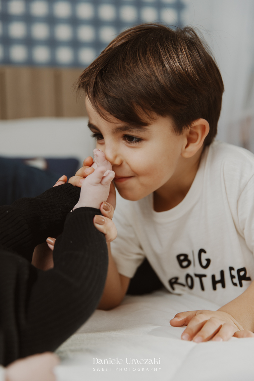 Família reunida durante ensaio lifestyle em casa em Arujá com o bebê Enrico de 2 meses, registrado por Dani Umezaki com fotografia leve, natural e atemporal