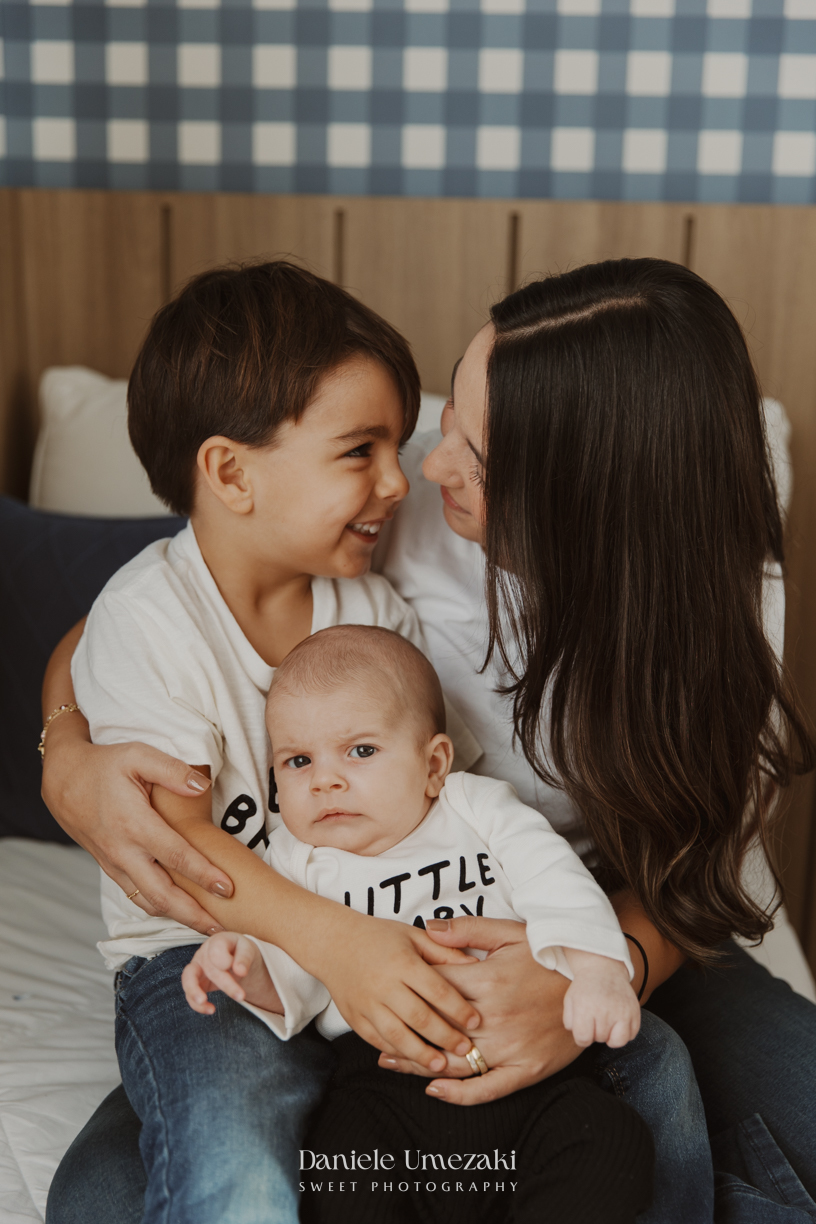 Família reunida durante ensaio lifestyle em casa em Arujá com o bebê Enrico de 2 meses, registrado por Dani Umezaki com fotografia leve, natural e atemporal