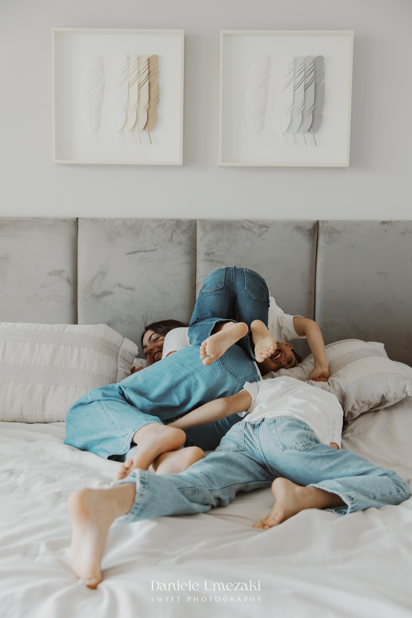 Família reunida durante ensaio lifestyle em casa em Arujá com o bebê Enrico de 2 meses, registrado por Dani Umezaki com fotografia leve, natural e atemporal