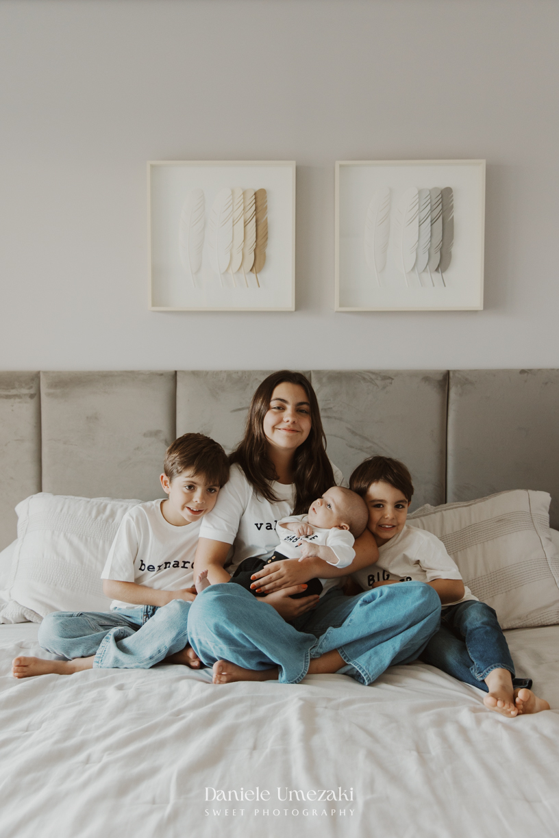 Família reunida durante ensaio lifestyle em casa em Arujá com o bebê Enrico de 2 meses, registrado por Dani Umezaki com fotografia leve, natural e atemporal