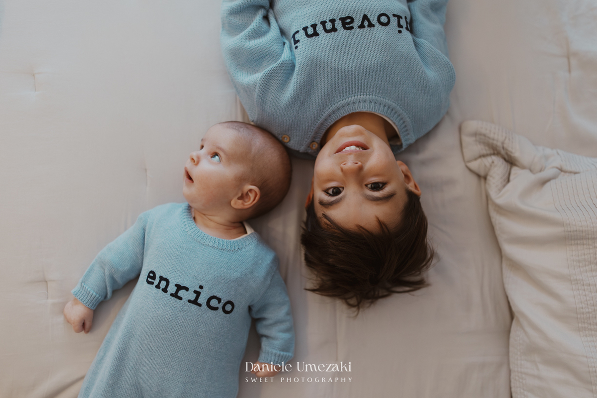 Família reunida durante ensaio lifestyle em casa em Arujá com o bebê Enrico de 2 meses, registrado por Dani Umezaki com fotografia leve, natural e atemporal