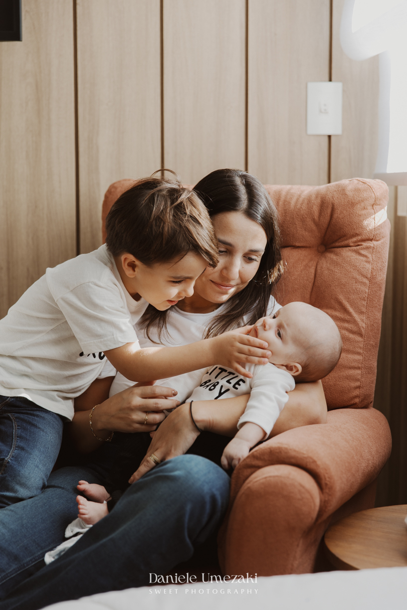 Família reunida durante ensaio lifestyle em casa em Arujá com o bebê Enrico de 2 meses, registrado por Dani Umezaki com fotografia leve, natural e atemporal