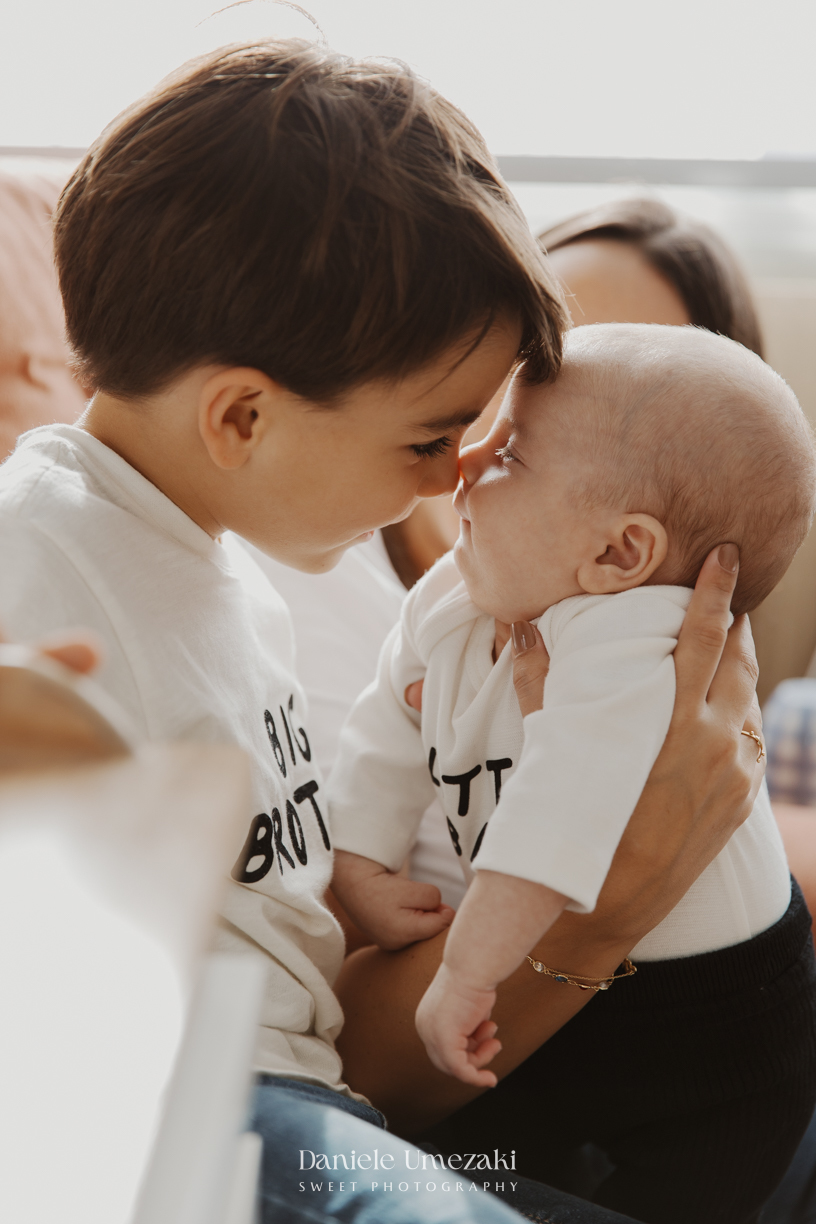 Família reunida durante ensaio lifestyle em casa em Arujá com o bebê Enrico de 2 meses, registrado por Dani Umezaki com fotografia leve, natural e atemporal