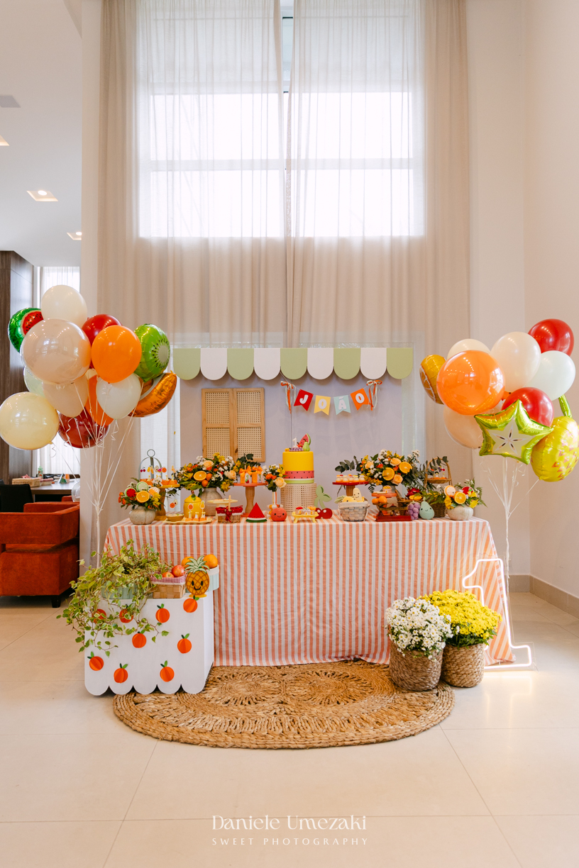 João comemorando seu aniversário de 1 ano com tema de frutas em festa realizada no salão do condomínio, com decoração da Cerejeira Decora e fotografia de Dani Umezaki.