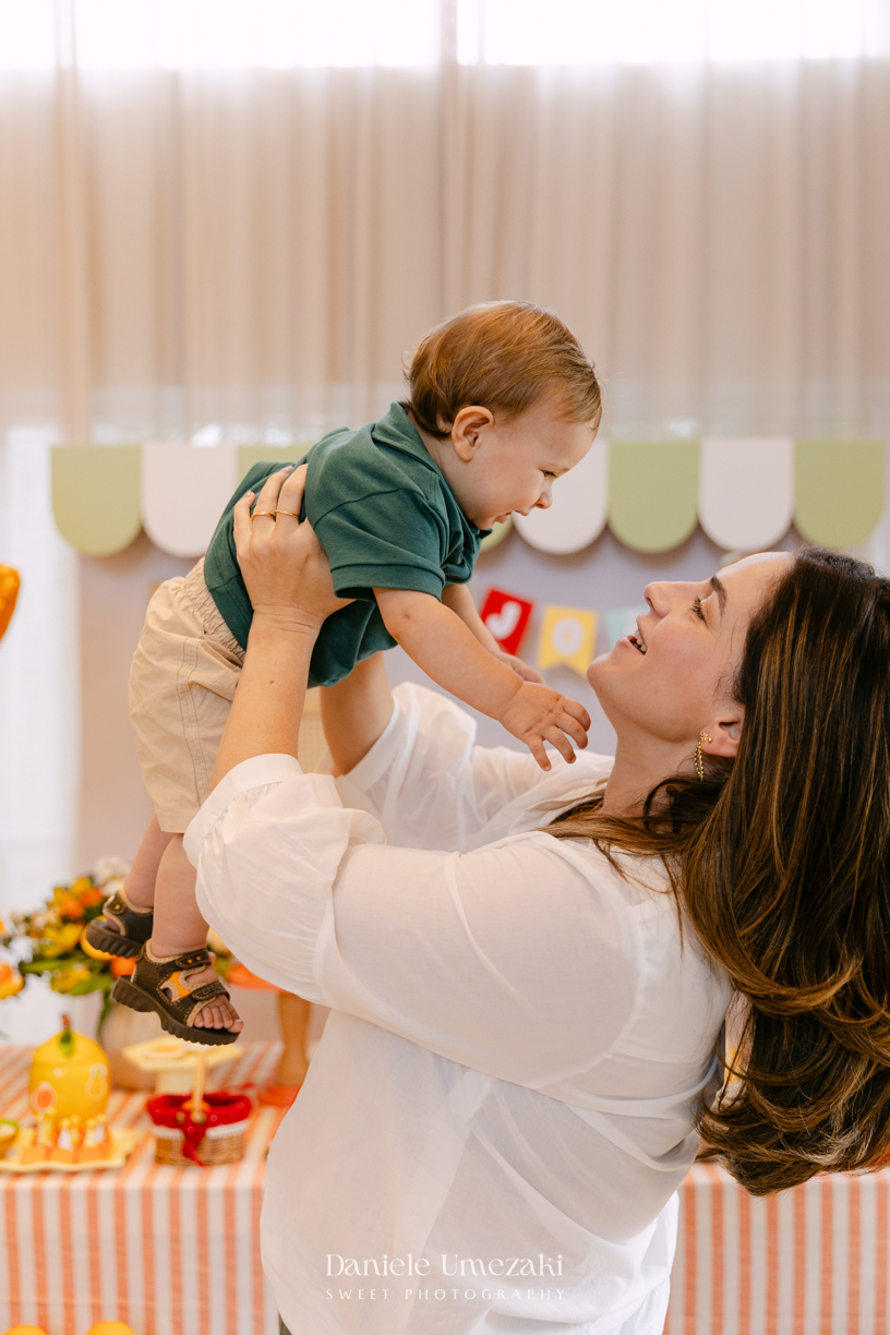 João comemorando seu aniversário de 1 ano com tema de frutas em festa realizada no salão do condomínio, com decoração da Cerejeira Decora e fotografia de Dani Umezaki.