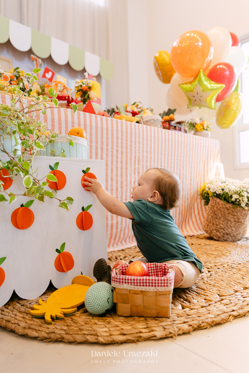 João comemorando seu aniversário de 1 ano com tema de frutas em festa realizada no salão do condomínio, com decoração da Cerejeira Decora e fotografia de Dani Umezaki.