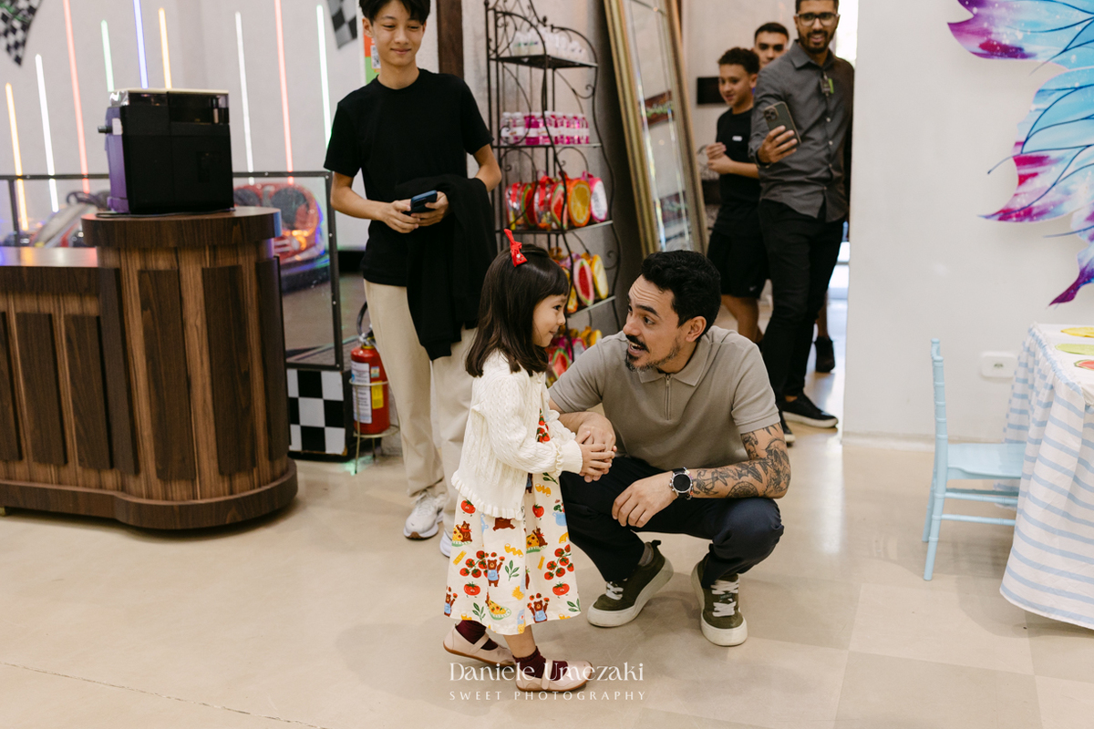 Maya sorrindo em frente à decoração de feira criada pela Panda Pink durante seu aniversário de 4 anos no Buffet Santa Arruaça, em Arujá.