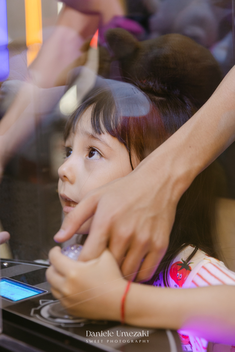 Maya sorrindo em frente à decoração de feira criada pela Panda Pink durante seu aniversário de 4 anos no Buffet Santa Arruaça, em Arujá.