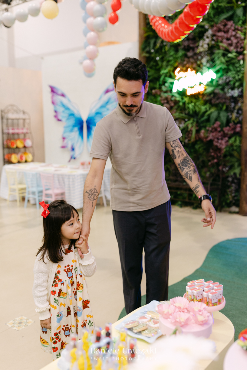 Maya sorrindo em frente à decoração de feira criada pela Panda Pink durante seu aniversário de 4 anos no Buffet Santa Arruaça, em Arujá.