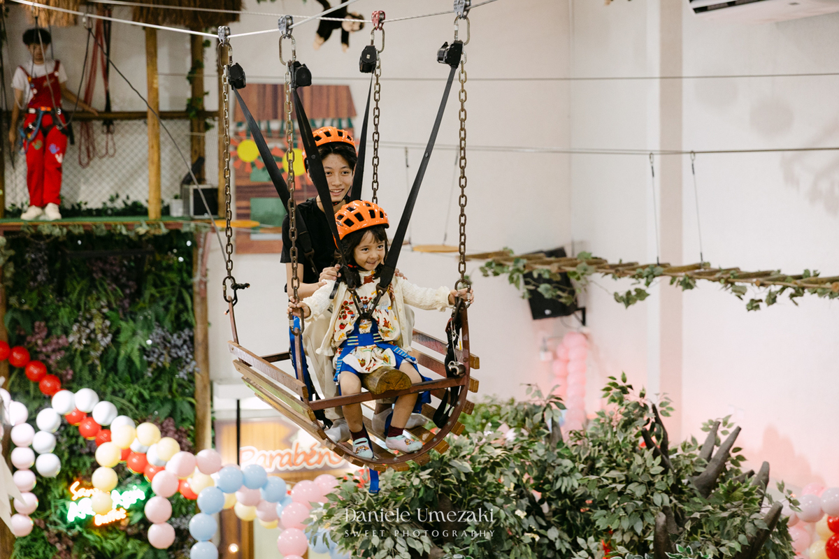 Maya sorrindo em frente à decoração de feira criada pela Panda Pink durante seu aniversário de 4 anos no Buffet Santa Arruaça, em Arujá.