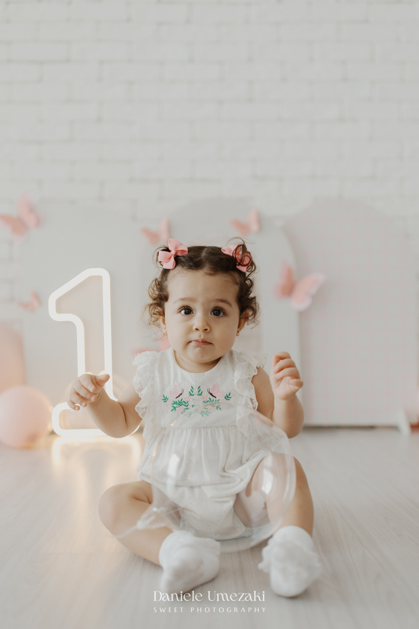 Sofia durante ensaio de 1 ano em estúdio com cenário clean e minimalista em Mogi das Cruzes, fotografada por Dani Umezaki.