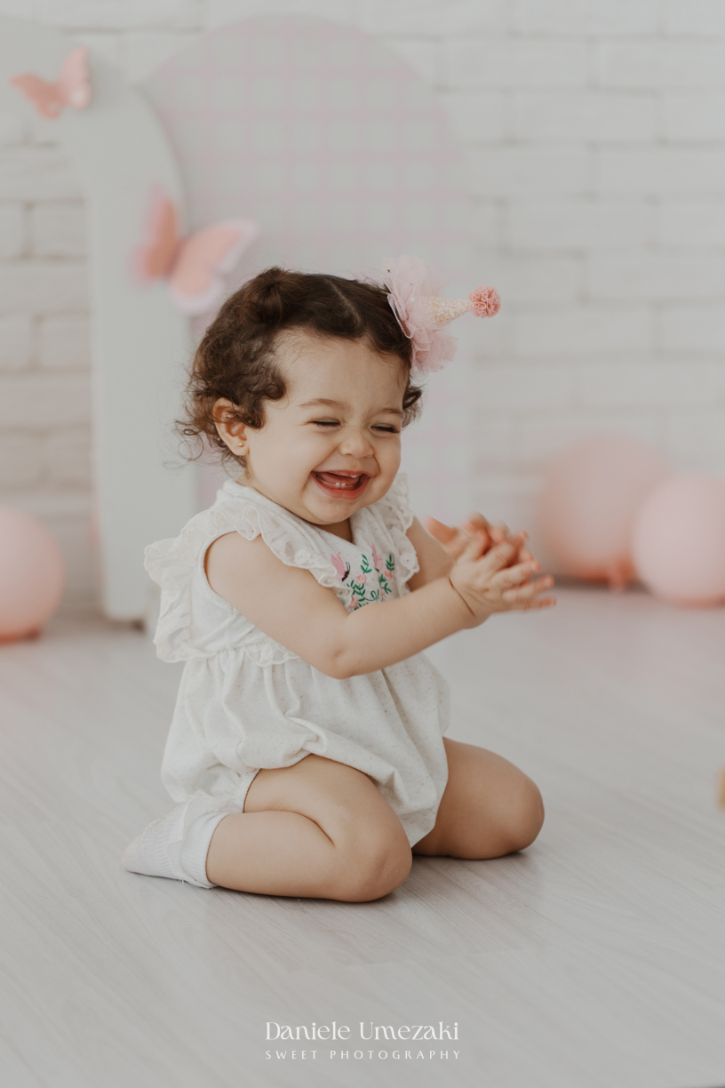 Sofia durante ensaio de 1 ano em estúdio com cenário clean e minimalista em Mogi das Cruzes, fotografada por Dani Umezaki.