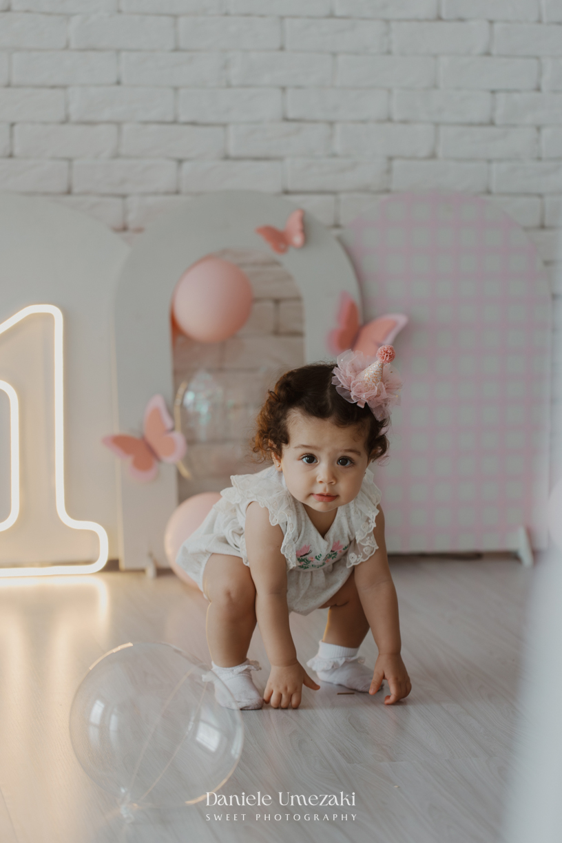 Sofia durante ensaio de 1 ano em estúdio com cenário clean e minimalista em Mogi das Cruzes, fotografada por Dani Umezaki.