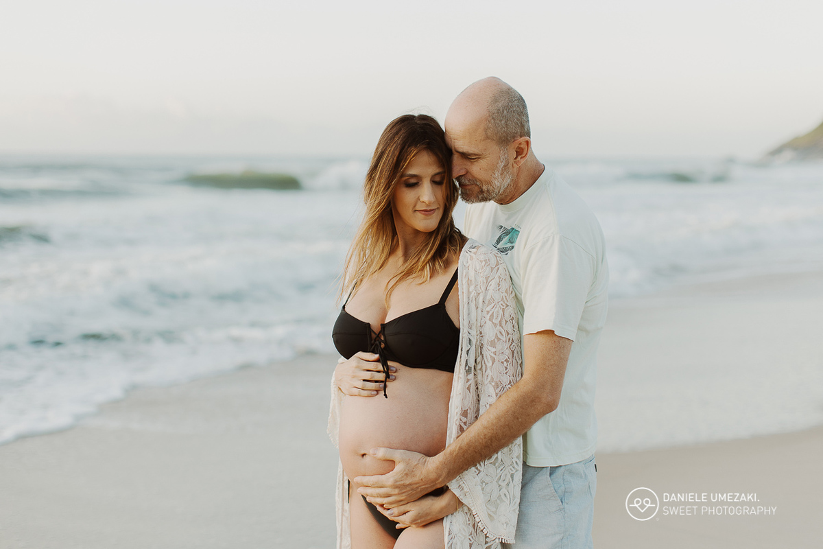 Iris e Antonio Carlos durante ensaio gestante na praia ao nascer do sol, esperando a chegada da pequena Carolina