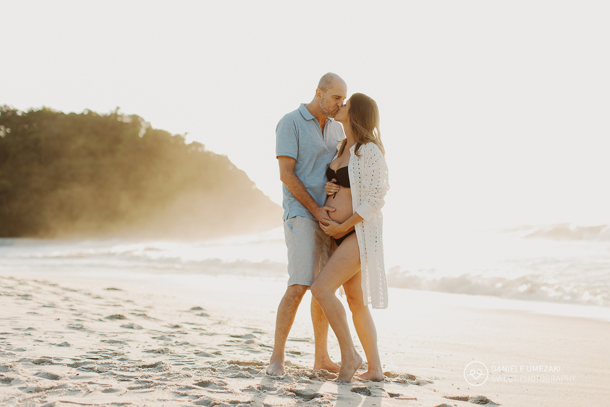 Iris e Antonio Carlos durante ensaio gestante na praia ao nascer do sol, esperando a chegada da pequena Carolina