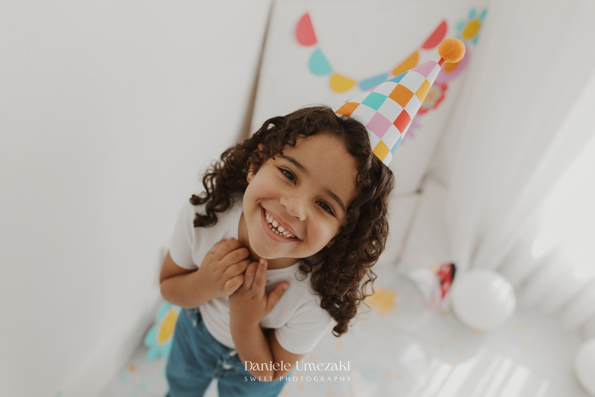 Agnes durante ensaio infantil de 3 anos em estúdio em Mogi das Cruzes, comemorando seu aniversário com pintura em tela, bolo e a companhia da irmã.