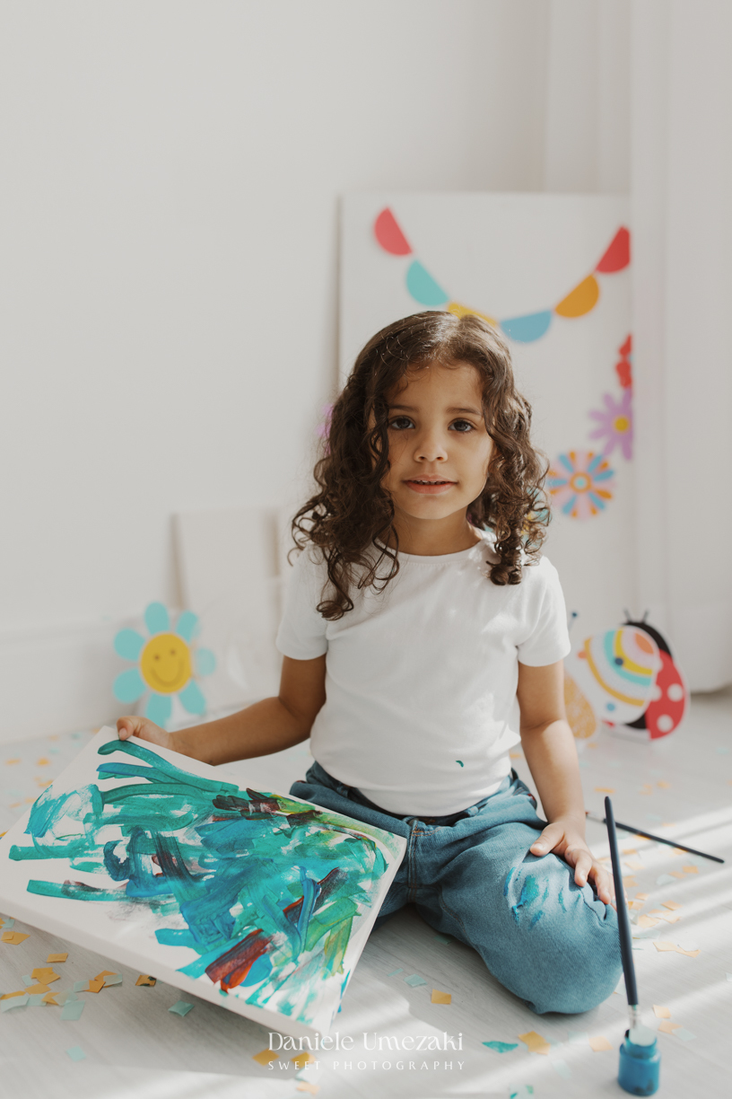 Agnes durante ensaio infantil de 3 anos em estúdio em Mogi das Cruzes, comemorando seu aniversário com pintura em tela, bolo e a companhia da irmã.