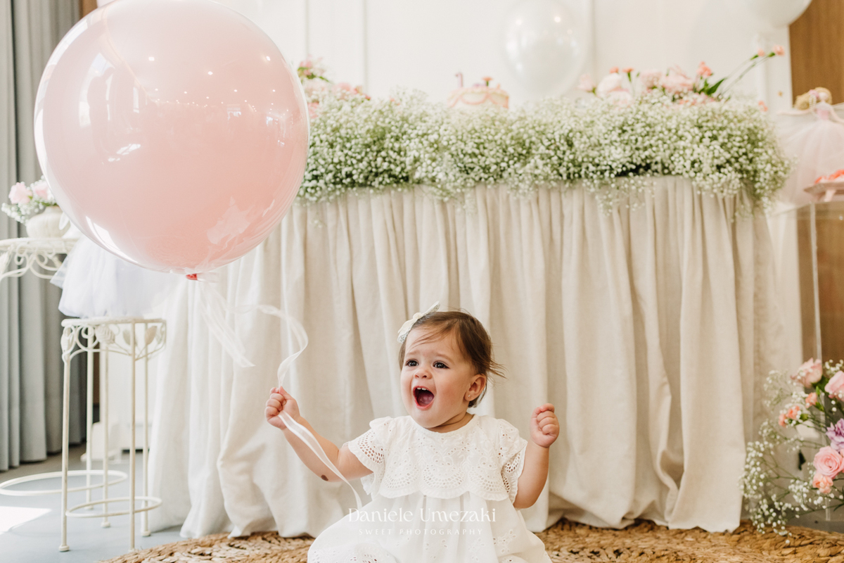 Olivia sorrindo durante sua festa de aniversário de 1 ano.
