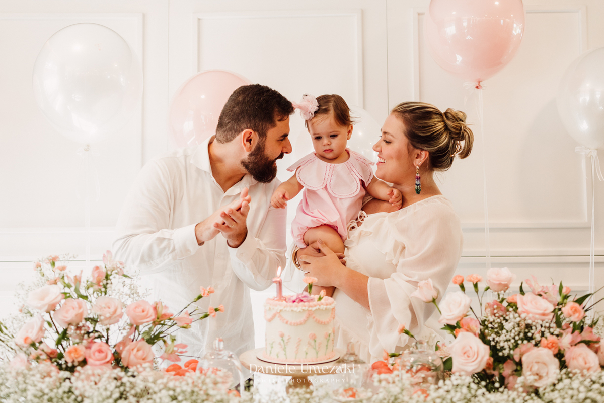 Momento dos parabéns no aniversário de 1 ano da Olivia, registrado com fotografia espontânea.