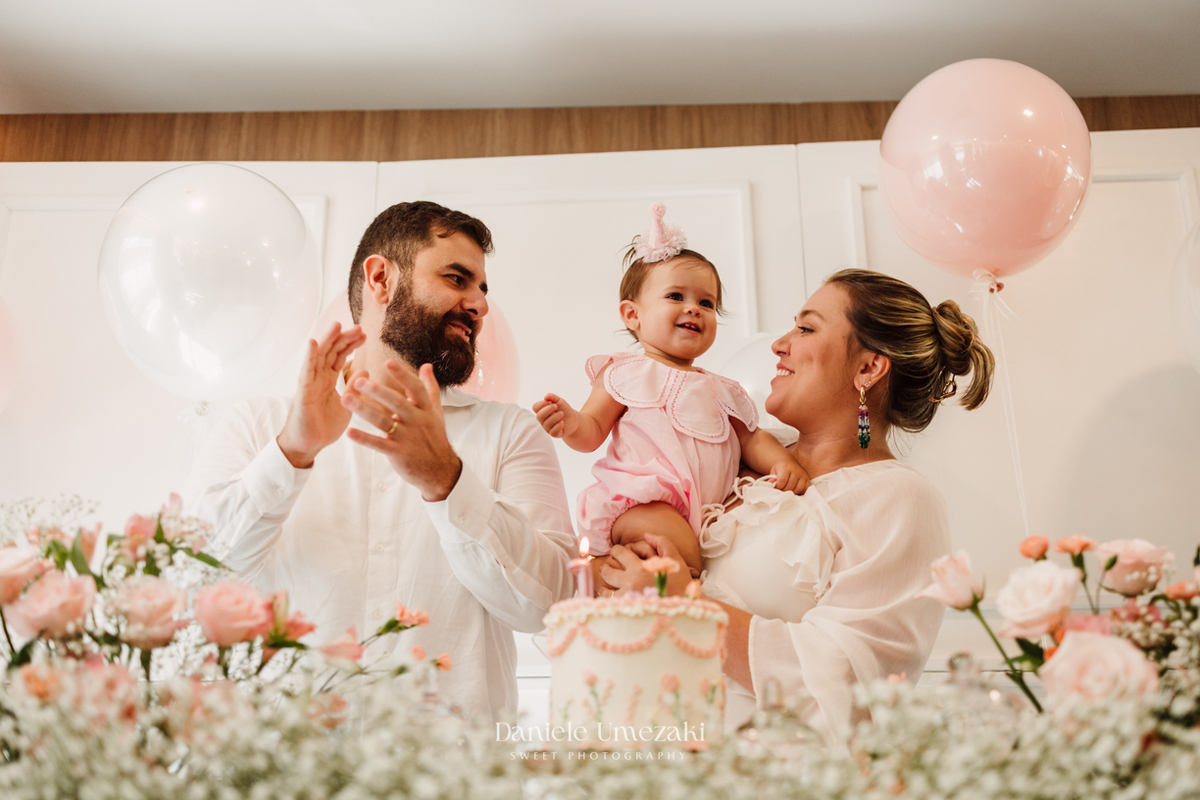 Momento dos parabéns no aniversário de 1 ano da Olivia, registrado com fotografia espontânea.