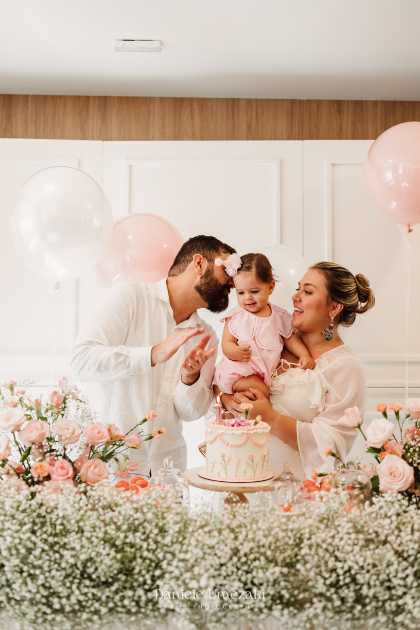 Momento dos parabéns no aniversário de 1 ano da Olivia, registrado com fotografia espontânea.