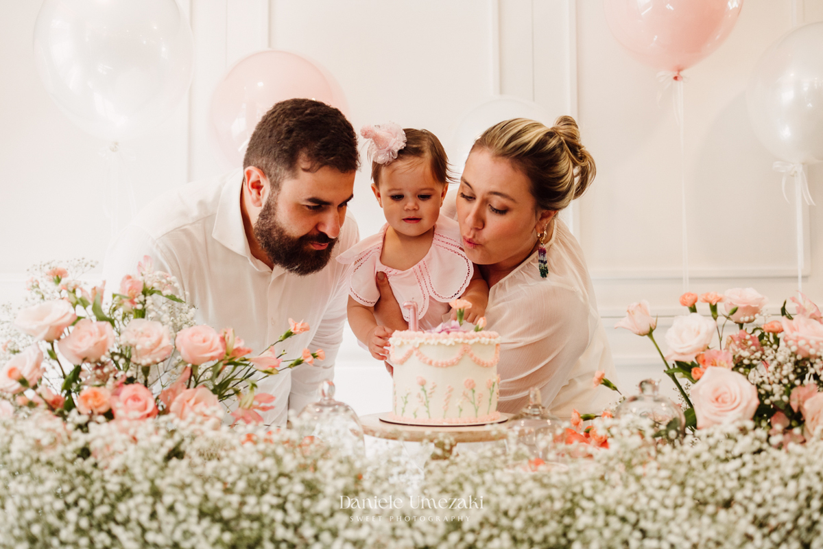 Momento dos parabéns no aniversário de 1 ano da Olivia, registrado com fotografia espontânea.