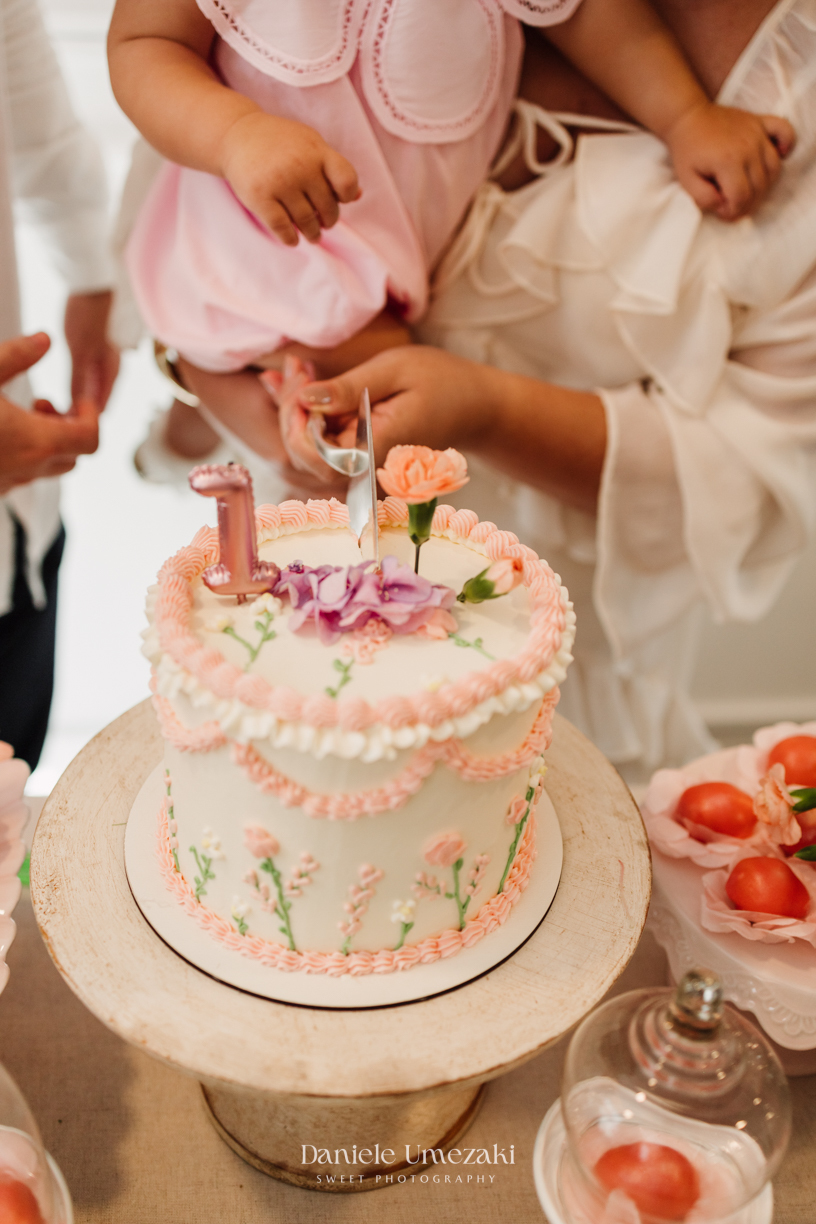 Momento dos parabéns no aniversário de 1 ano da Olivia, registrado com fotografia espontânea.