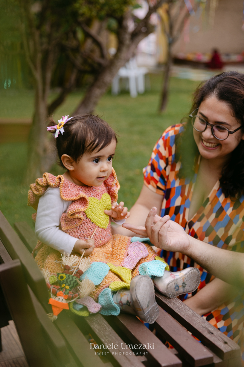 Amália comemorando seu primeiro aniversário em uma delicada festa junina no Quintal Pitangueiras, em Mogi das Cruzes, cercada pela família e amigos.