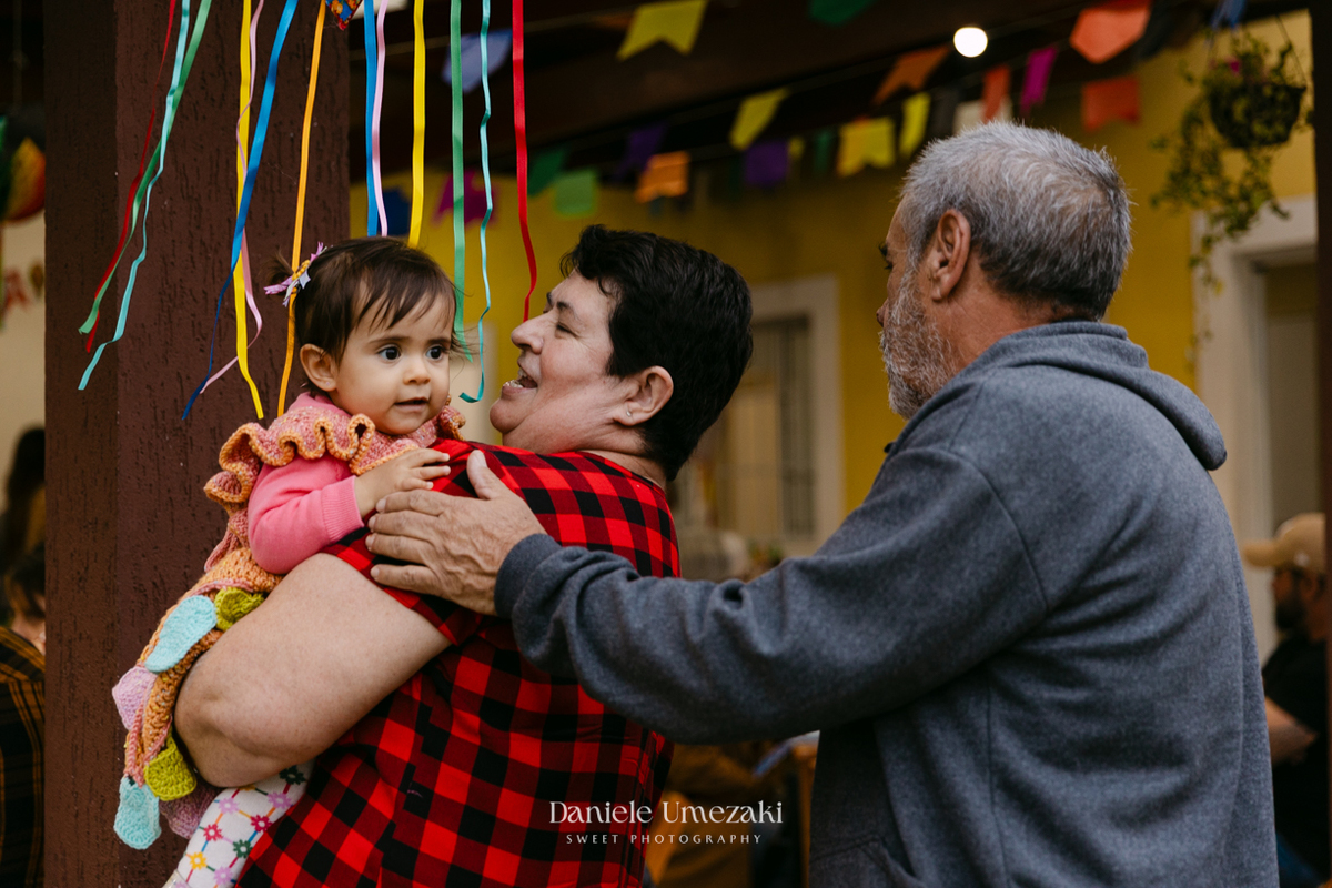 Amália comemorando seu primeiro aniversário em uma delicada festa junina no Quintal Pitangueiras, em Mogi das Cruzes, cercada pela família e amigos.