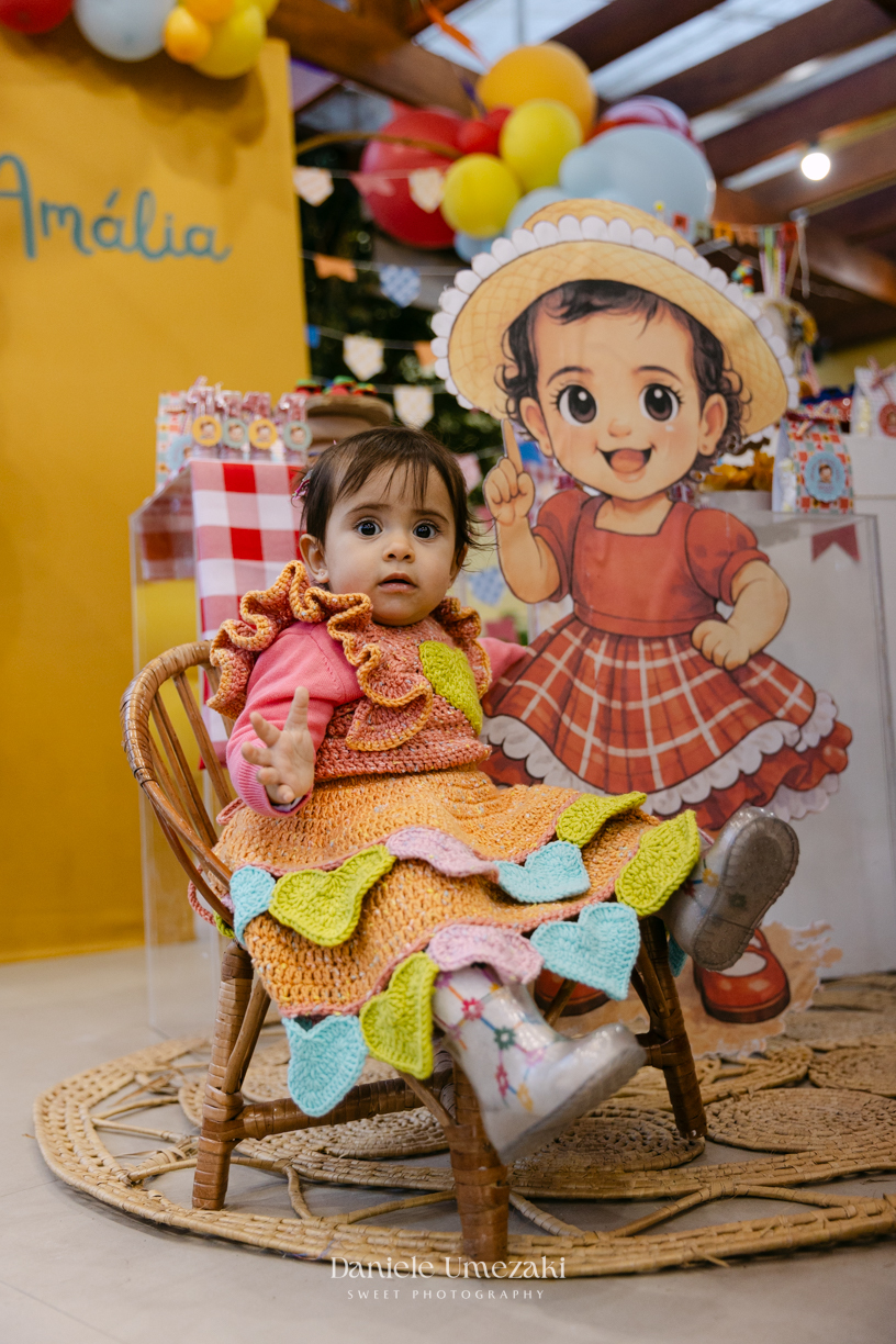 Amália comemorando seu primeiro aniversário em uma delicada festa junina no Quintal Pitangueiras, em Mogi das Cruzes, cercada pela família e amigos.