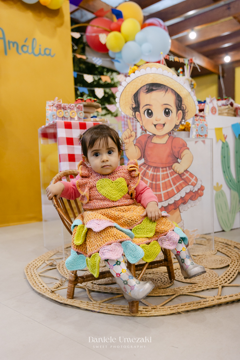 Amália comemorando seu primeiro aniversário em uma delicada festa junina no Quintal Pitangueiras, em Mogi das Cruzes, cercada pela família e amigos.