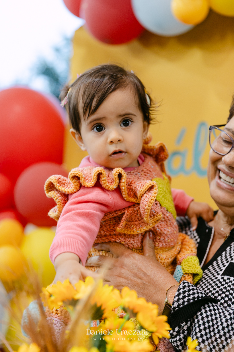 Amália comemorando seu primeiro aniversário em uma delicada festa junina no Quintal Pitangueiras, em Mogi das Cruzes, cercada pela família e amigos.