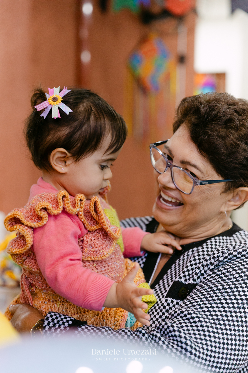 Amália comemorando seu primeiro aniversário em uma delicada festa junina no Quintal Pitangueiras, em Mogi das Cruzes, cercada pela família e amigos.