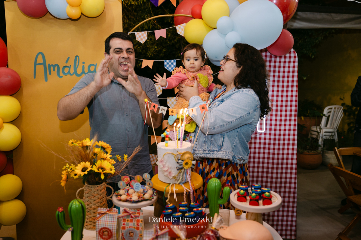 Amália comemorando seu primeiro aniversário em uma delicada festa junina no Quintal Pitangueiras, em Mogi das Cruzes, cercada pela família e amigos.