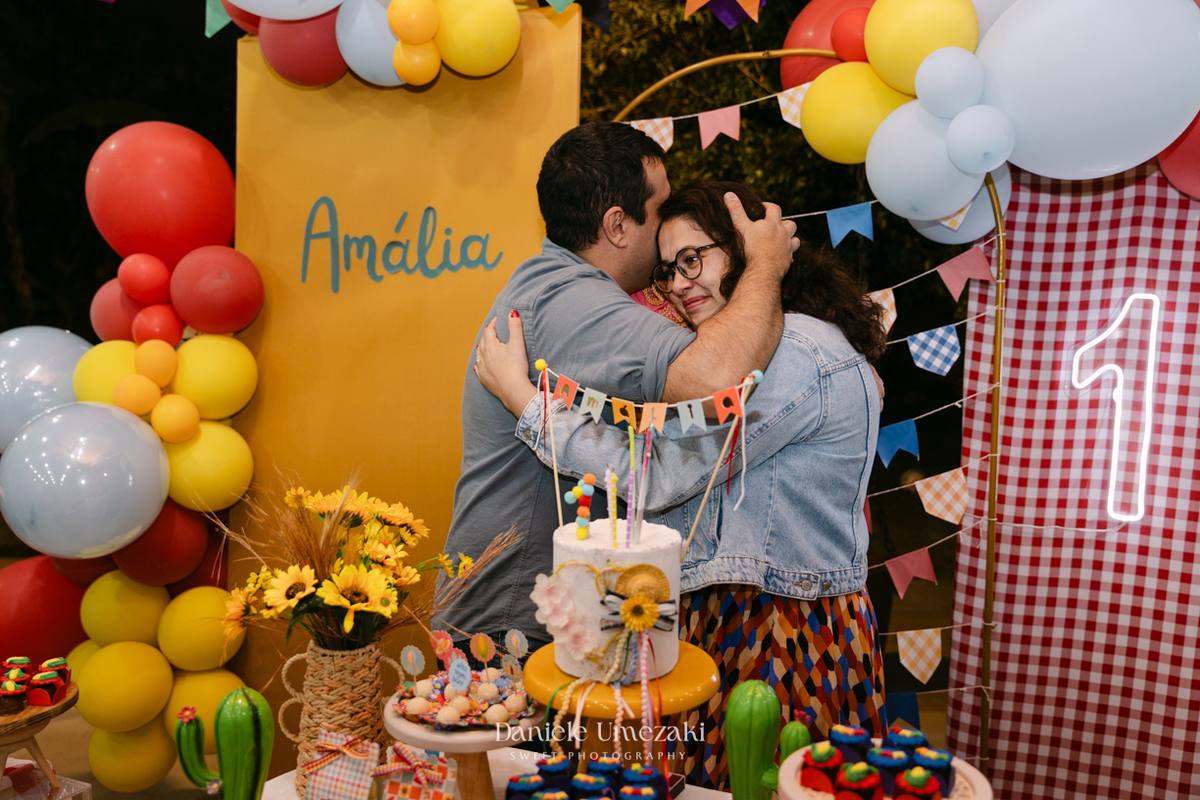Amália comemorando seu primeiro aniversário em uma delicada festa junina no Quintal Pitangueiras, em Mogi das Cruzes, cercada pela família e amigos.