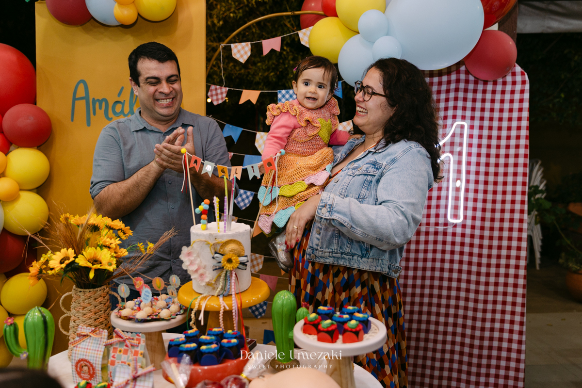 Amália comemorando seu primeiro aniversário em uma delicada festa junina no Quintal Pitangueiras, em Mogi das Cruzes, cercada pela família e amigos.