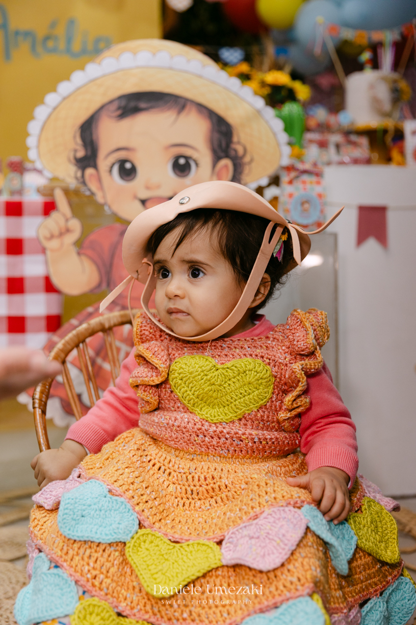 Amália comemorando seu primeiro aniversário em uma delicada festa junina no Quintal Pitangueiras, em Mogi das Cruzes, cercada pela família e amigos.