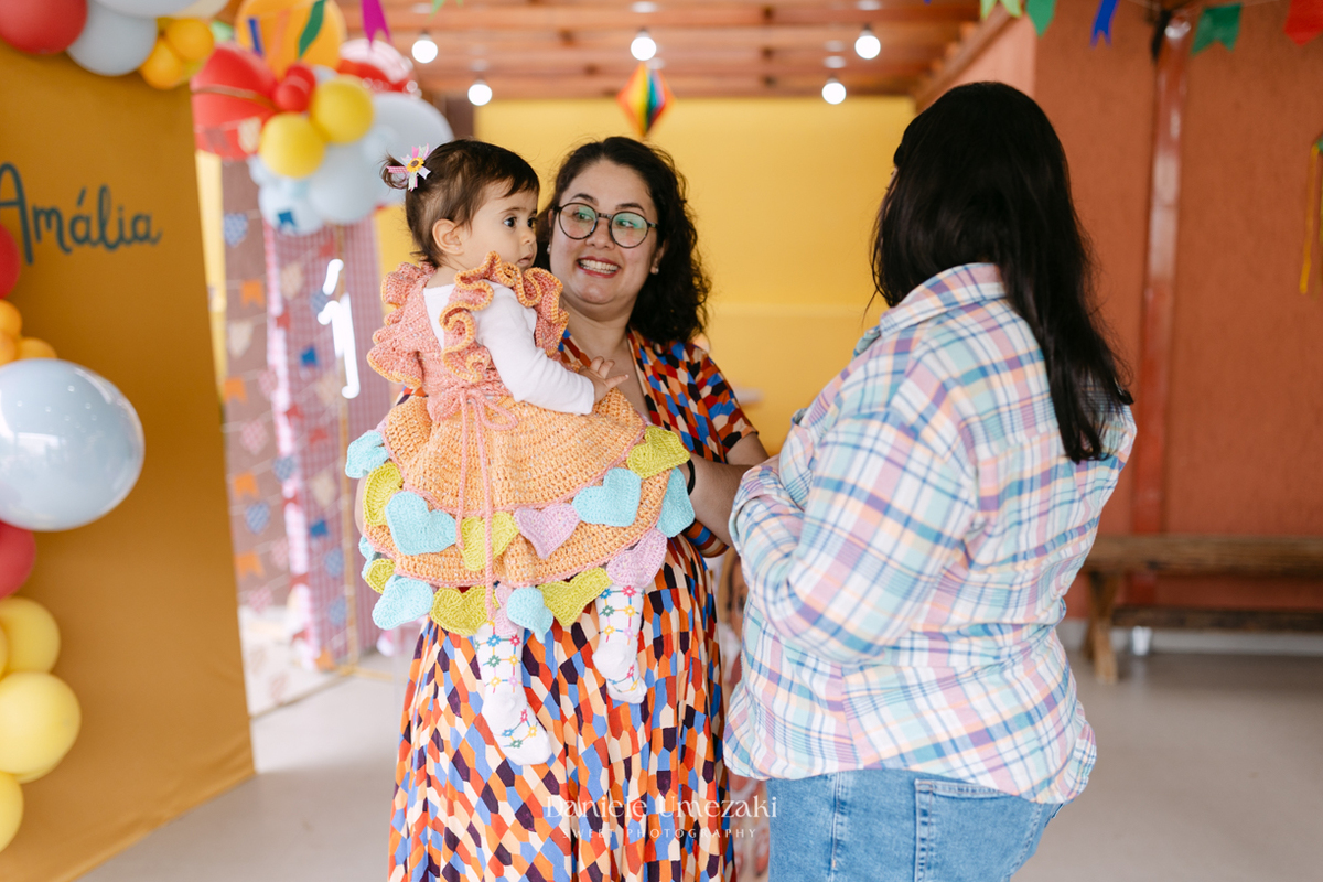 Amália comemorando seu primeiro aniversário em uma delicada festa junina no Quintal Pitangueiras, em Mogi das Cruzes, cercada pela família e amigos.
