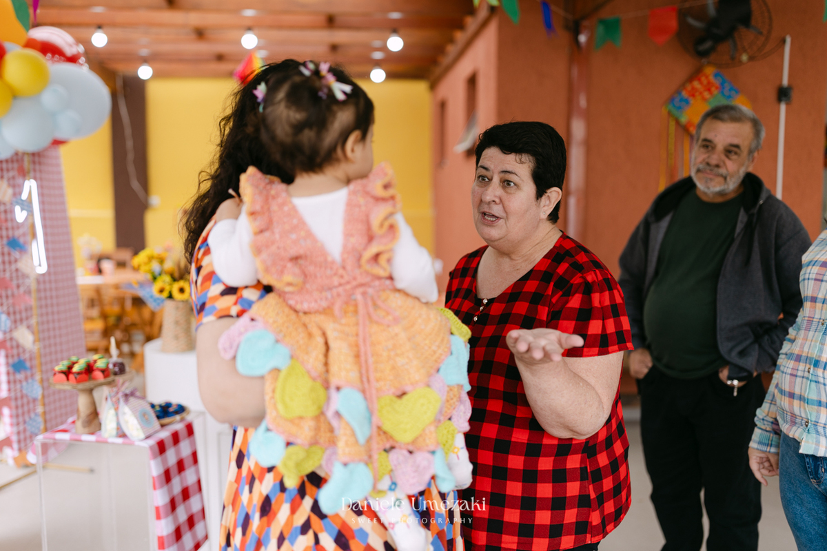 Amália comemorando seu primeiro aniversário em uma delicada festa junina no Quintal Pitangueiras, em Mogi das Cruzes, cercada pela família e amigos.