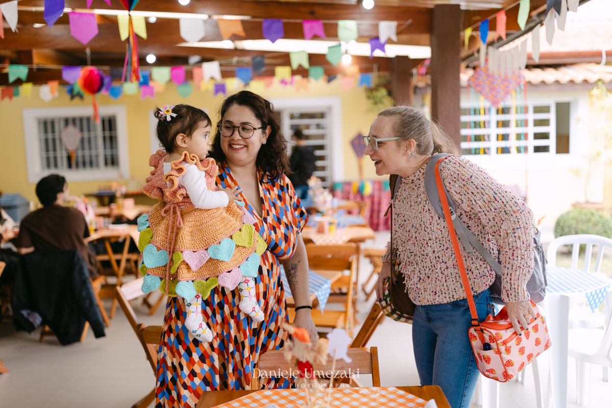 Amália comemorando seu primeiro aniversário em uma delicada festa junina no Quintal Pitangueiras, em Mogi das Cruzes, cercada pela família e amigos.