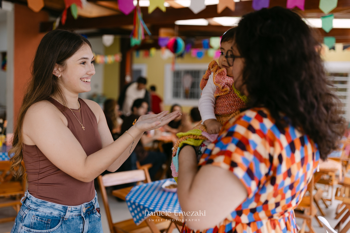 Amália comemorando seu primeiro aniversário em uma delicada festa junina no Quintal Pitangueiras, em Mogi das Cruzes, cercada pela família e amigos.