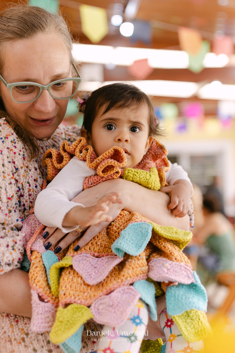 Amália comemorando seu primeiro aniversário em uma delicada festa junina no Quintal Pitangueiras, em Mogi das Cruzes, cercada pela família e amigos.