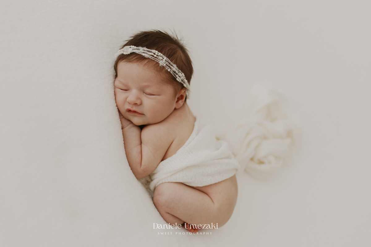 Ensaio newborn em Mogi das Cruzes com fotografia delicada, natural e atemporal. Conheça os primeiros dias da Lia registrados no estúdio Dani Umezaki Sweet Photography, especializado em fotografias de recém-nascidos e famílias.