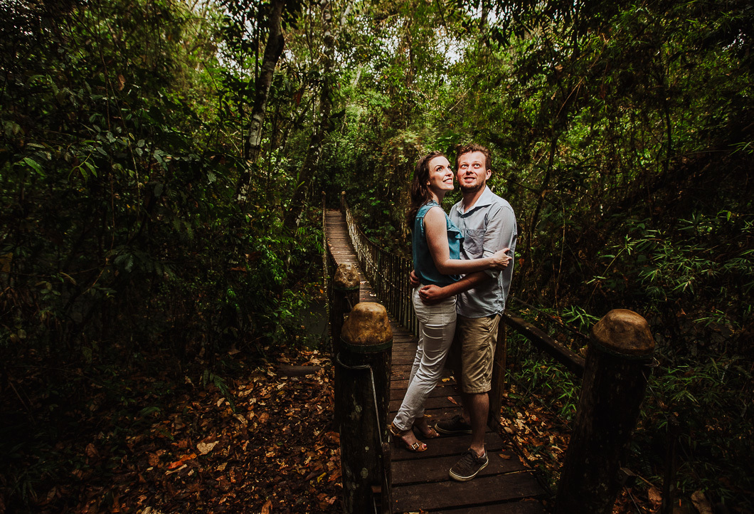 casal abraçado em ponte de madeira